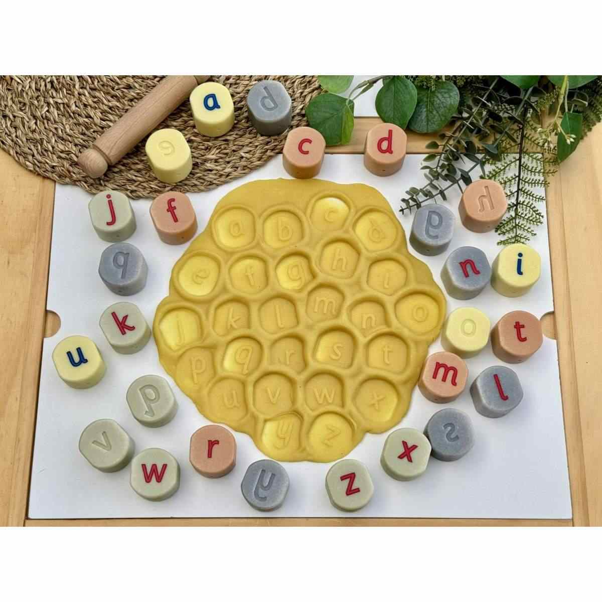 Yellow Door alfabet stempelstenen set met 26 kleine letters rond gele stempelplaat, losse steentjes alfabetisch gerangschikt