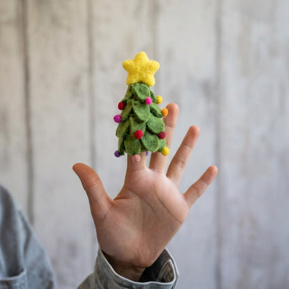 Sjaal met Verhaal vingerpopje kerstboom: groen vilten miniatuurboom met gele ster en gekleurde bolletjes op kinderhand