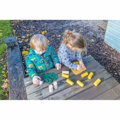 Yellow Door Let's Roll kleirollers met insectenmotieven gebruikt door twee kinderen op houten tafel, gele en natuurlijke stempels zichtbaar