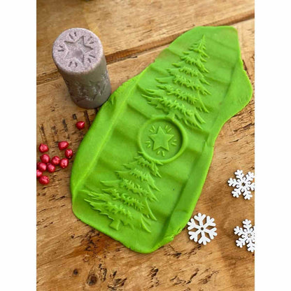 Yellow Door knetroller seizoenen met winter-thema: groene roller met kerstboom en ster naast grijze stempel, op houten ondergrond met rode kralen en w