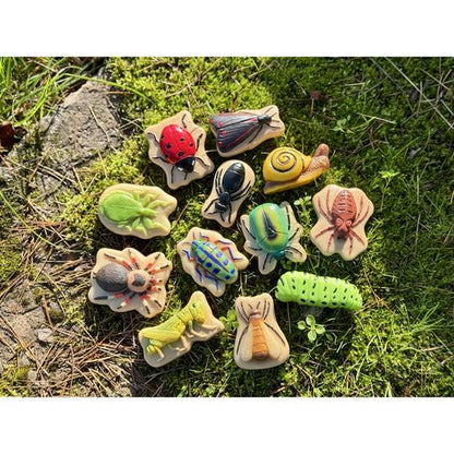 Yellow Door sensorische speelstenen met 12 verschillende insecten in cirkelformatie op groen gras, bovenaanzicht met tactiele details